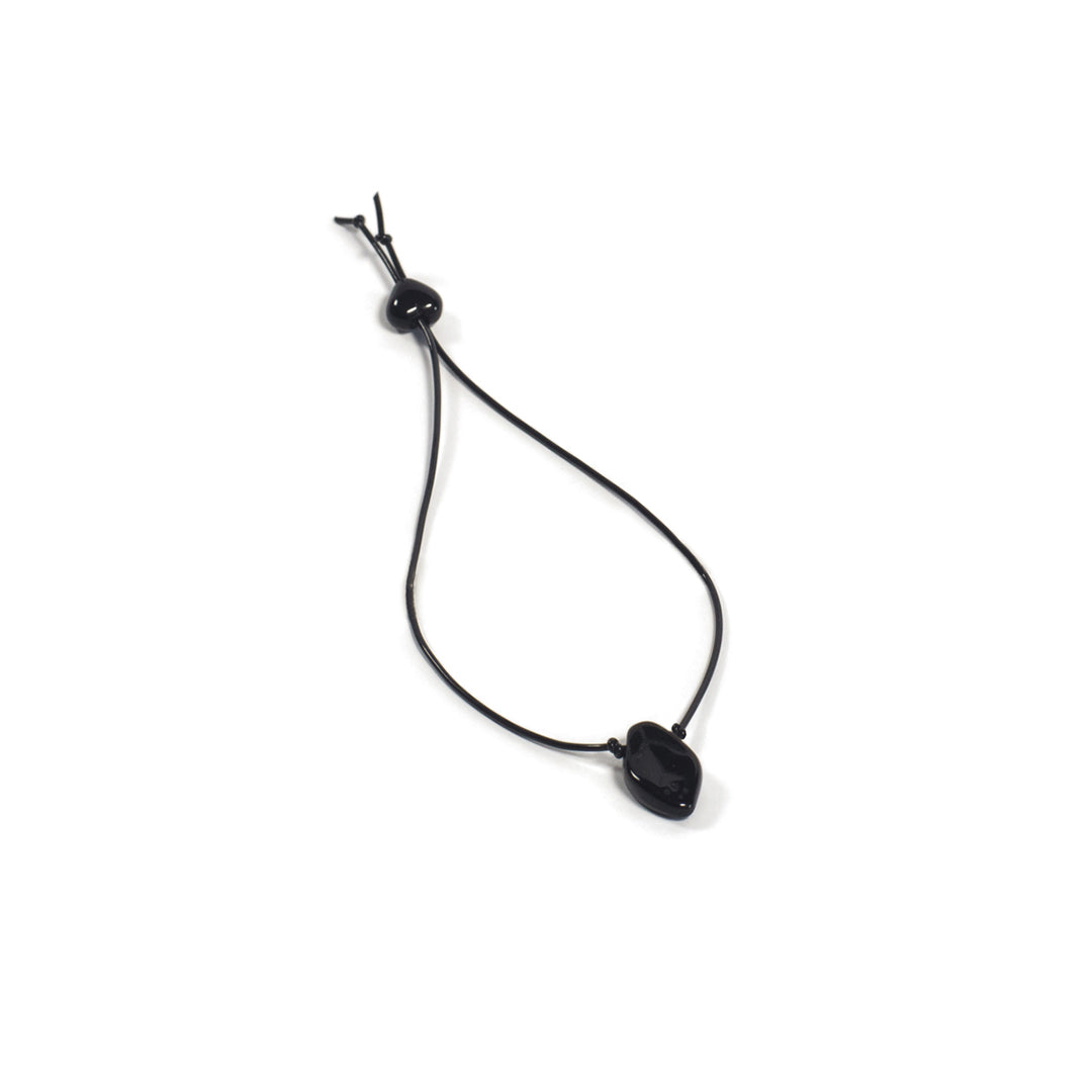 Pulsera elástica negra con micro hoja. Es ajustable, liviana, cómoda y atemporal. Diseño conceptual latinoamericano.