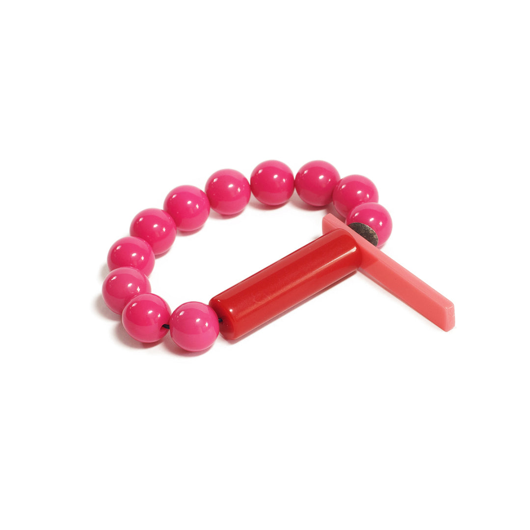 Pulsera fucsia elástica, liviana, cómoda, versátil y atemporal. Diseño conceptual latinoamericano. Escala macro.